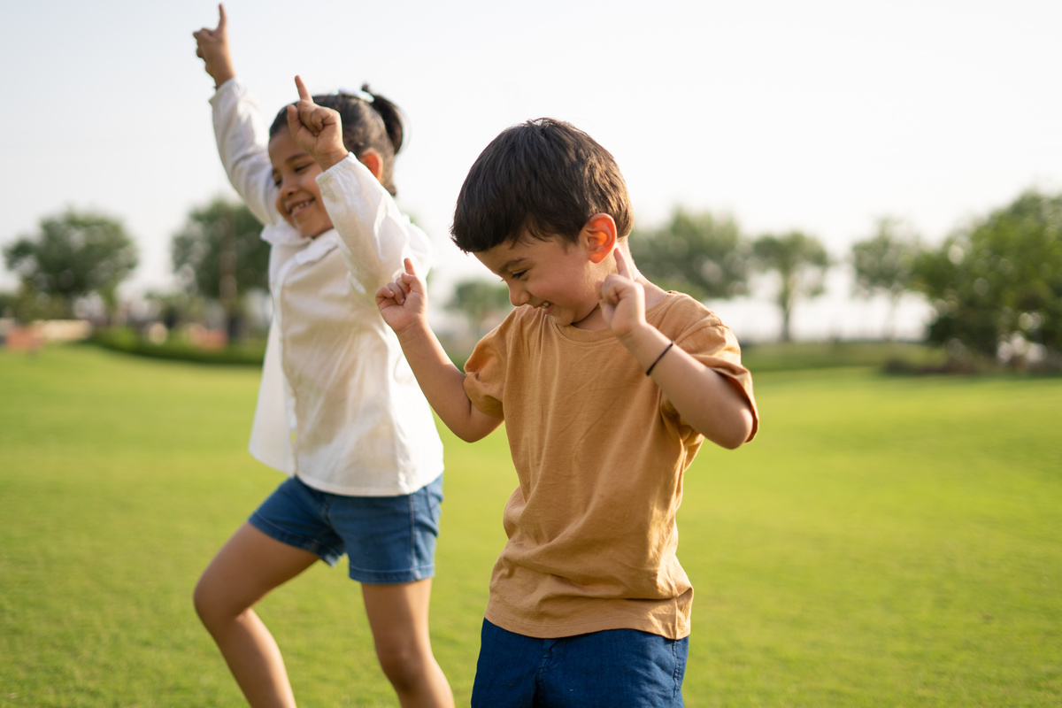 Happy Children Dancing Together in the Park